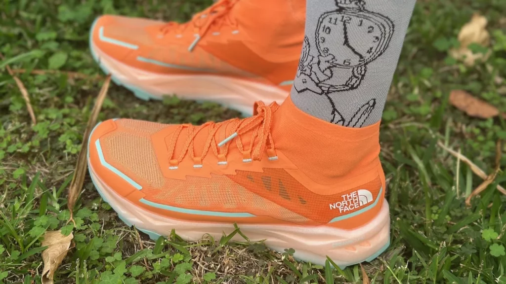Chaussure de trail The North Face Offtrail Ultra orange portée, montrant le laçage et la guêtre intégrée autour de la cheville.