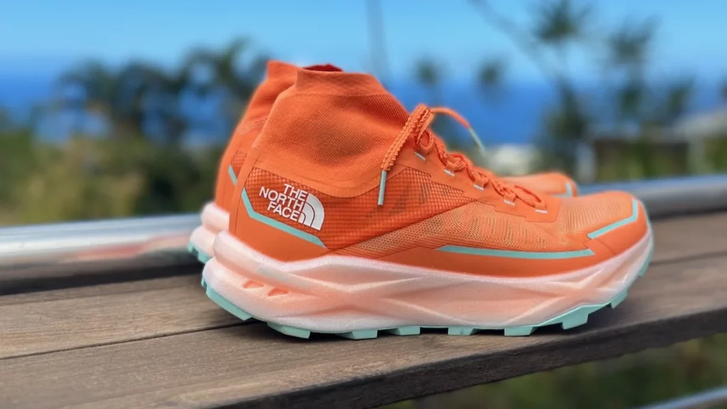 Vue latérale de la chaussure The North Face Offtrail Ultra orange montrant sa guêtre intégrée et son épaisse semelle intermédiaire.